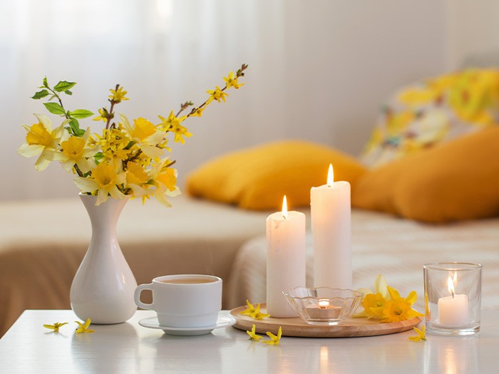 Table basse garnie d’un vase de fleurs et de bougies.
